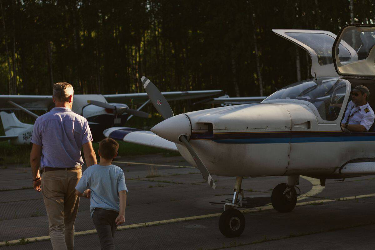 Small aircraft on the tarmac with people exploring.