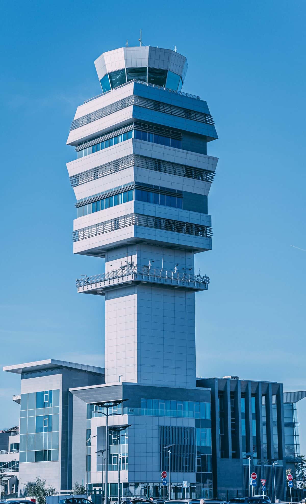 Control tower with a modern, angular design against a clear blue sky.