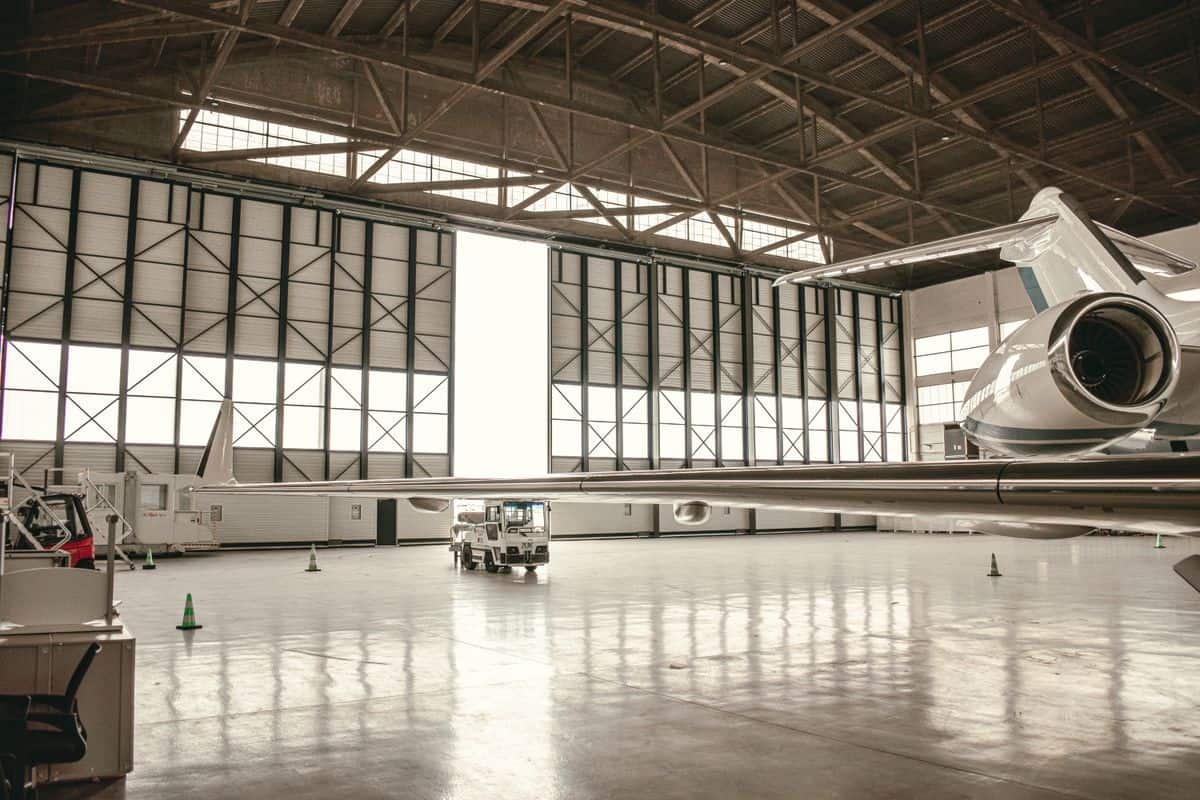 Private jet in a spacious hangar with architectural design elements