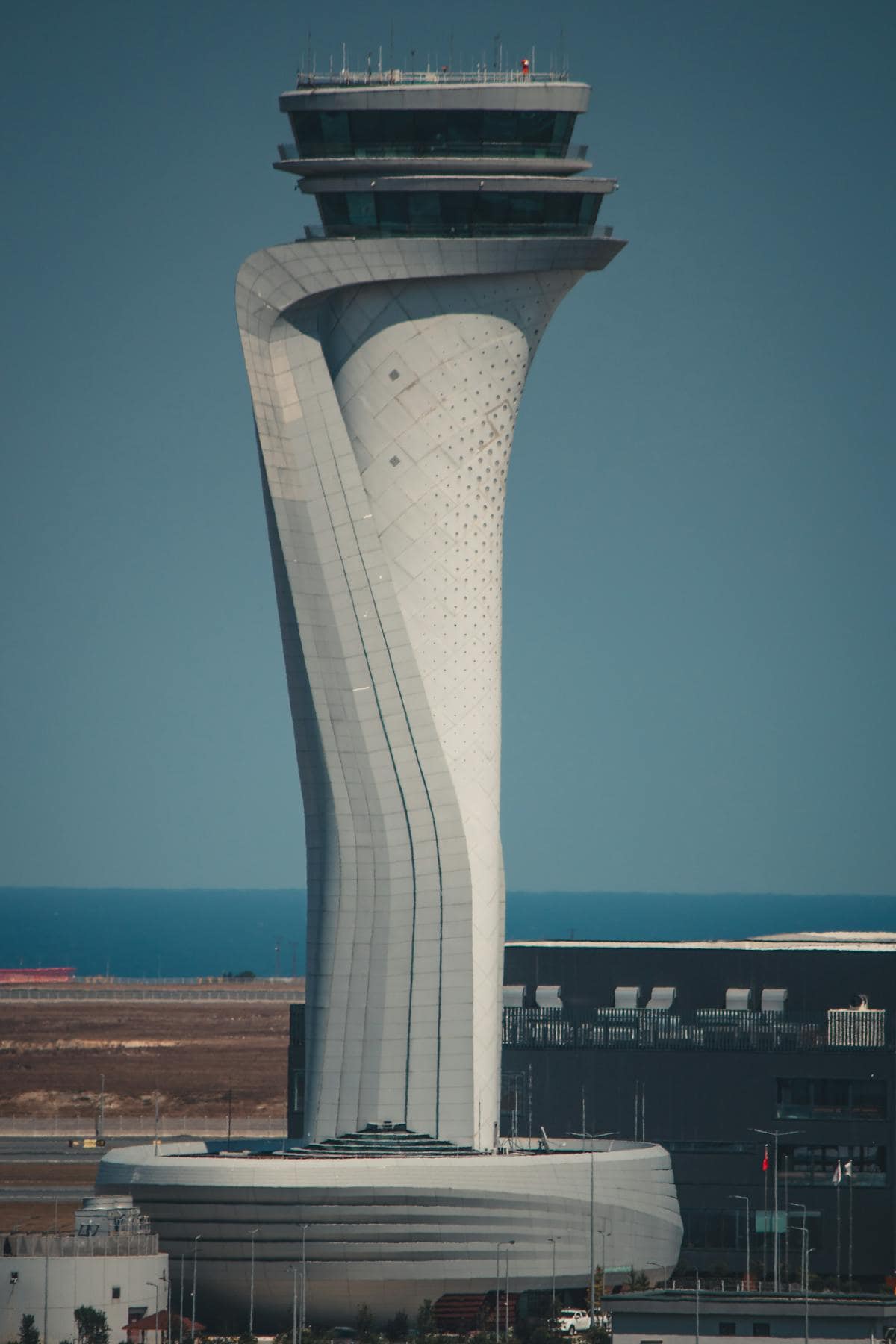 Modern aviation control tower with unique twisting design at an airport.