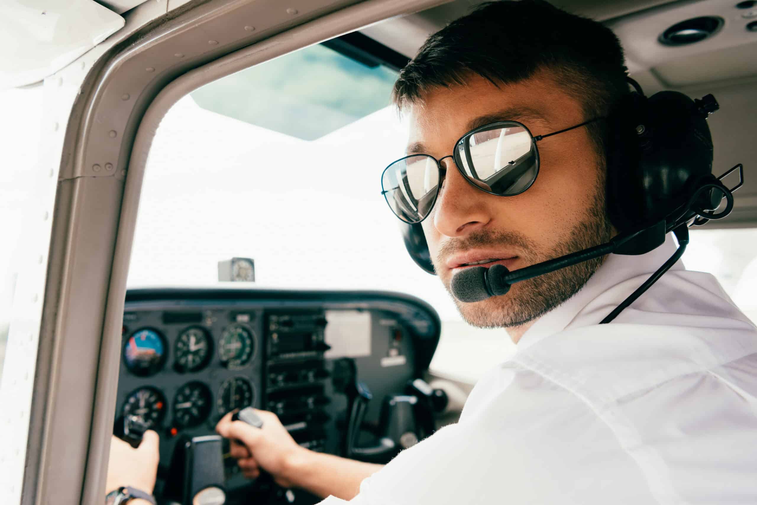 Pilot sunglasses fitted under an aviation headset clamp in a GA cockpit.