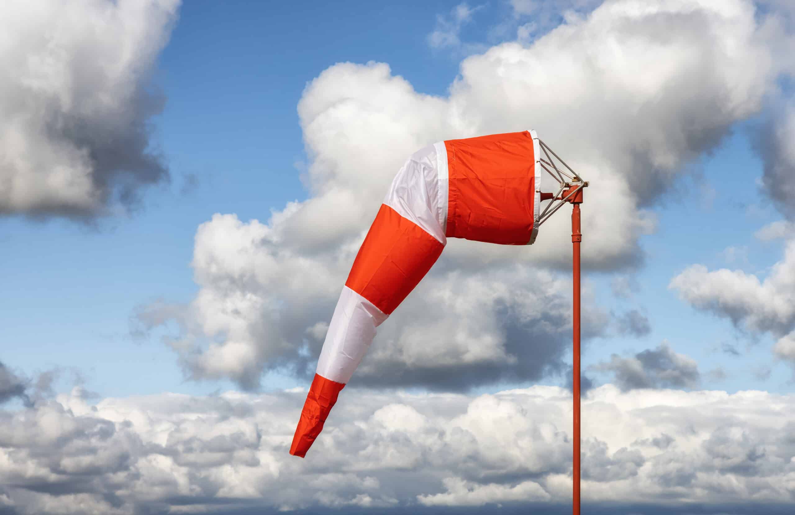Airport windsock fully extended against a blue sky - a ground-truth wind check on ATIS vs AWOS vs ASOS reports.