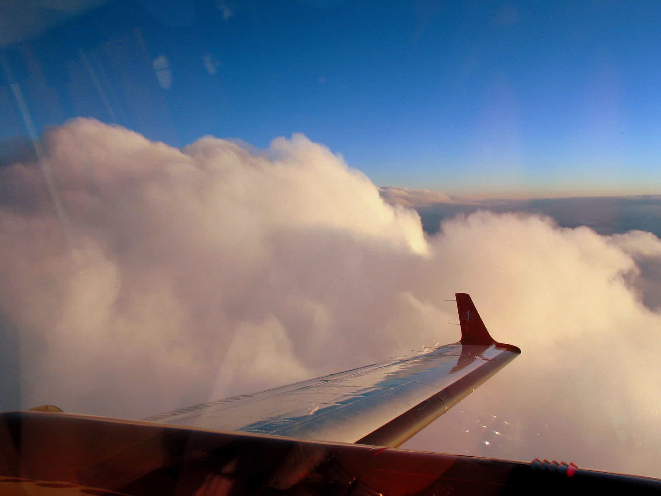 Towering cumulus buildup from a GA cockpit — reading PIREPs on turbulence starts with clouds shaped like this.